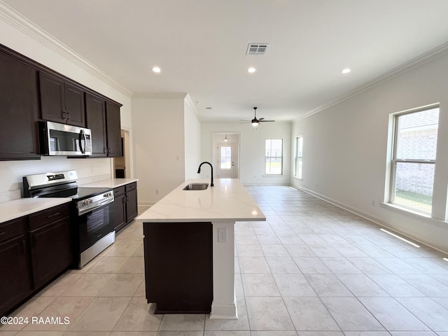 kitchen featuring ornamental molding, stainless steel appliances, ceiling fan, a kitchen island with sink, and sink