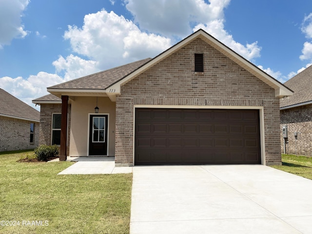 view of front of property with a garage and a front lawn