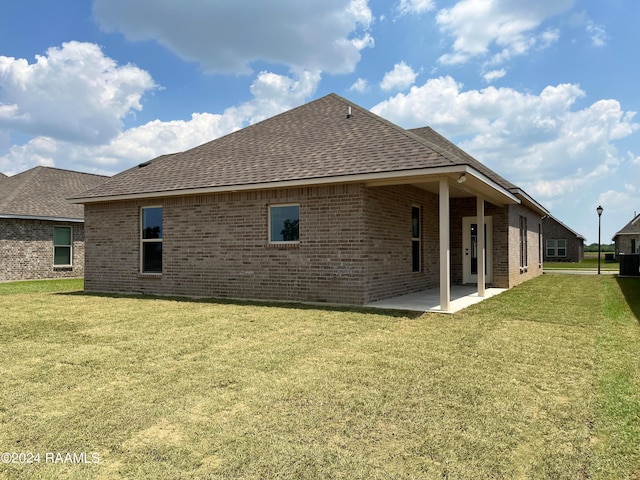 back of house featuring a patio and a lawn