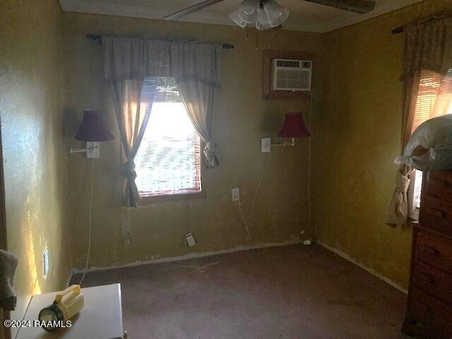 unfurnished room featuring ceiling fan and a wall mounted AC