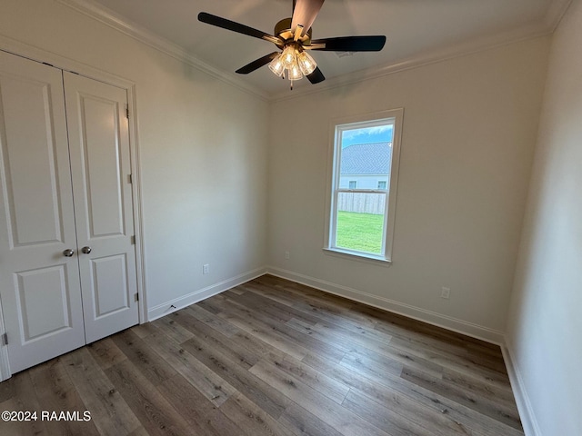 empty room with ornamental molding, light wood-type flooring, and ceiling fan