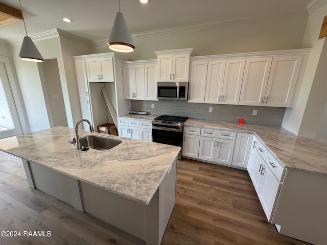 kitchen featuring dark hardwood / wood-style flooring, white cabinets, hanging light fixtures, sink, and appliances with stainless steel finishes