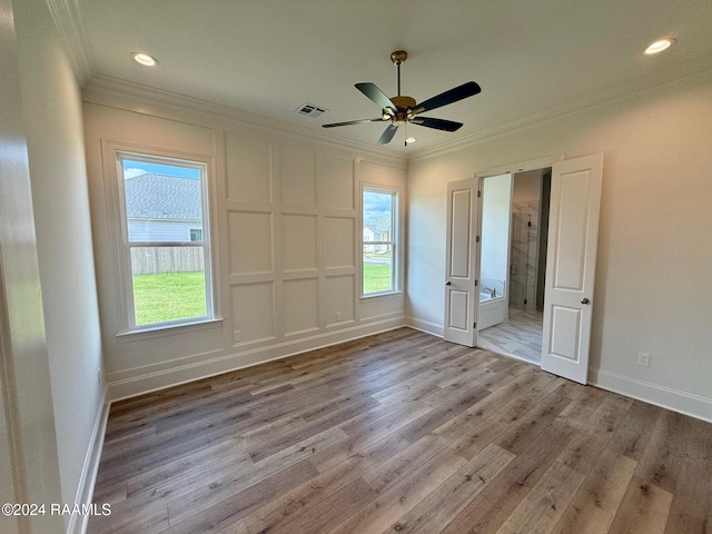 unfurnished bedroom featuring ornamental molding, light hardwood / wood-style floors, ceiling fan, and connected bathroom