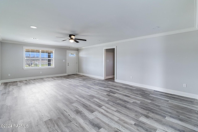 empty room with ornamental molding, ceiling fan, and light wood-type flooring