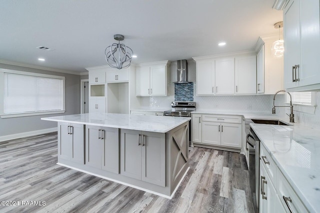 kitchen with an inviting chandelier, pendant lighting, light hardwood / wood-style flooring, light stone countertops, and wall chimney range hood