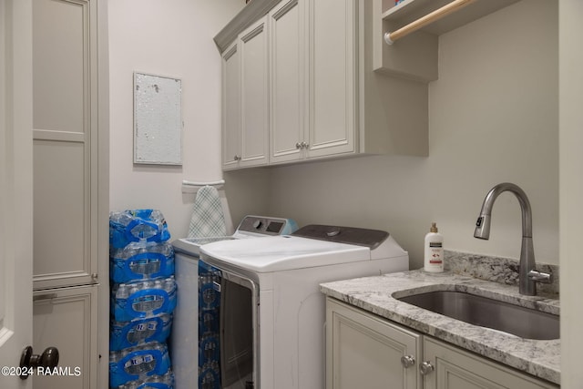 laundry area with washer and clothes dryer, sink, and cabinets