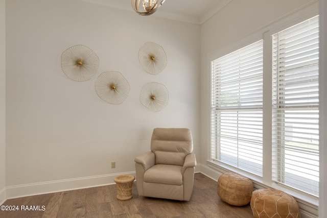 living area with a wealth of natural light, ornamental molding, and hardwood / wood-style flooring