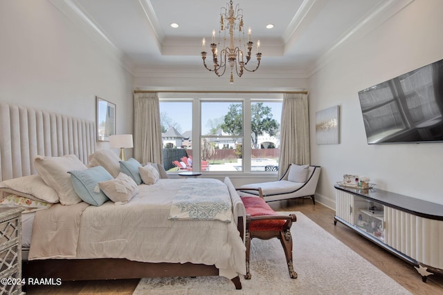 bedroom featuring crown molding, a raised ceiling, an inviting chandelier, and hardwood / wood-style floors