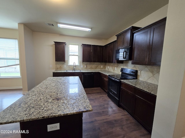 kitchen featuring black appliances, sink, decorative backsplash, a kitchen island, and dark hardwood / wood-style flooring