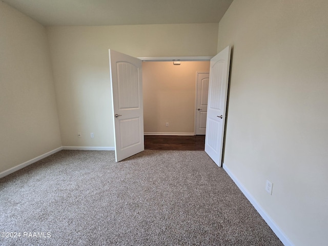 empty room featuring dark colored carpet