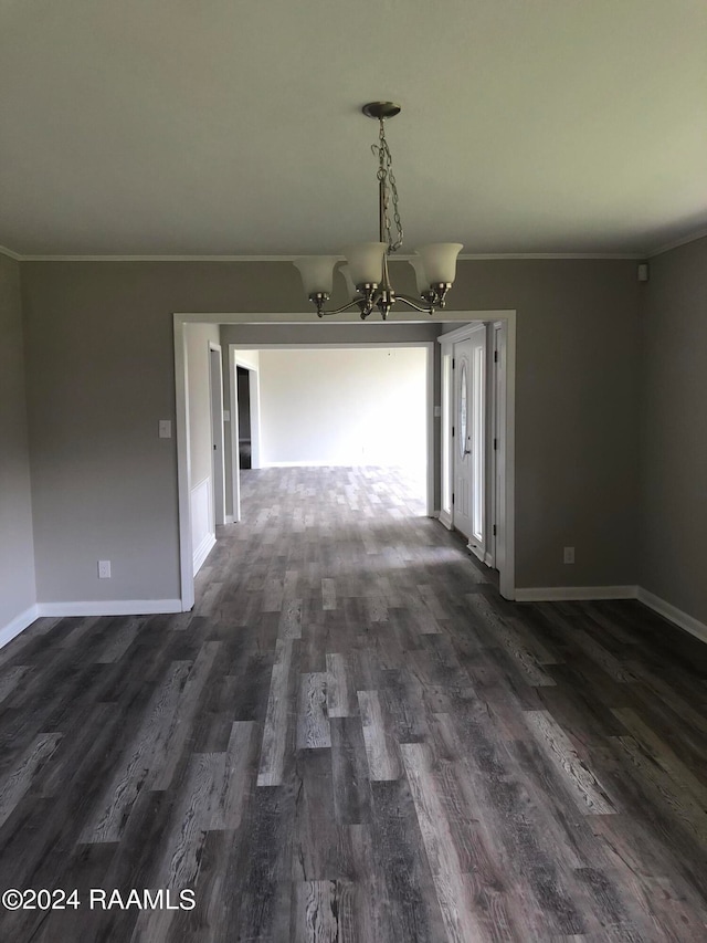 unfurnished room featuring ornamental molding, dark hardwood / wood-style floors, and an inviting chandelier