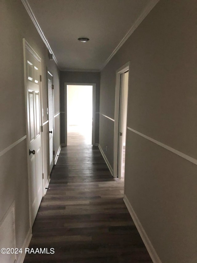 hallway featuring ornamental molding and dark hardwood / wood-style floors