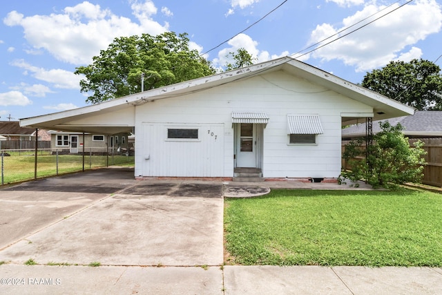 bungalow-style house featuring a carport and a front yard