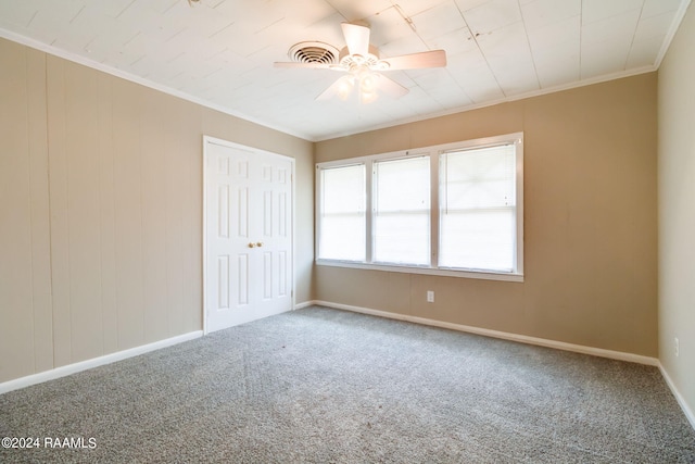 carpeted spare room with ceiling fan and crown molding