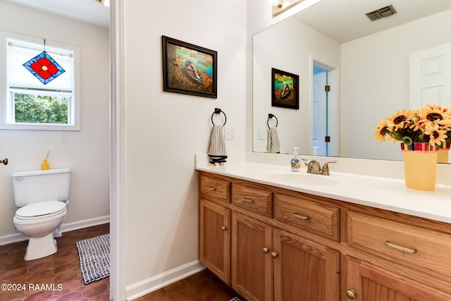 bathroom featuring vanity, toilet, and tile flooring