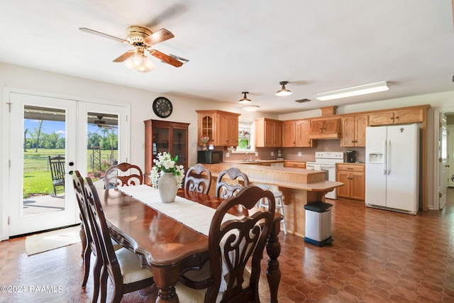 dining area featuring sink, ceiling fan, dark tile floors, and french doors