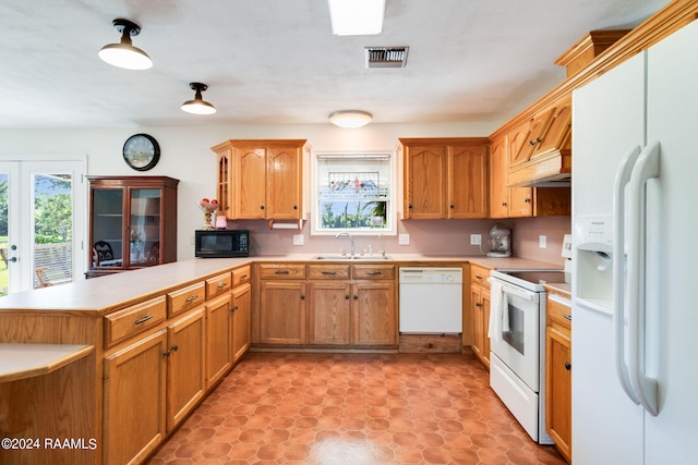 kitchen with custom exhaust hood, white appliances, kitchen peninsula, sink, and light tile floors