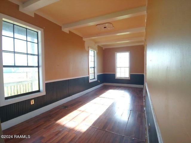 empty room featuring hardwood / wood-style floors and beam ceiling