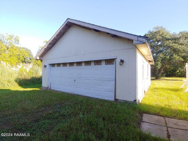 garage featuring wood walls and a lawn