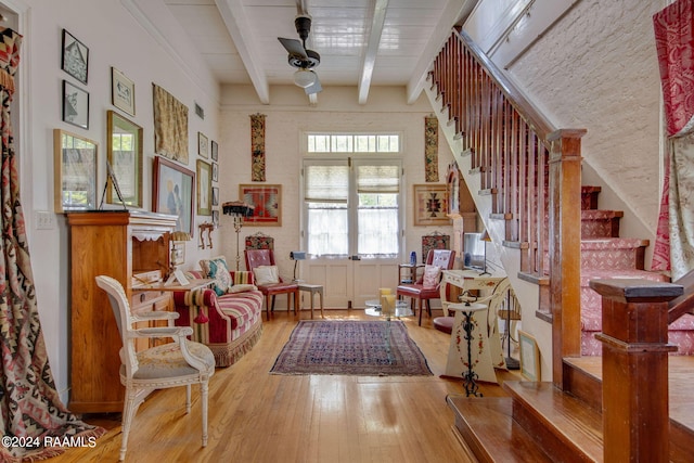 sitting room featuring hardwood / wood-style floors, beam ceiling, ceiling fan, and french doors