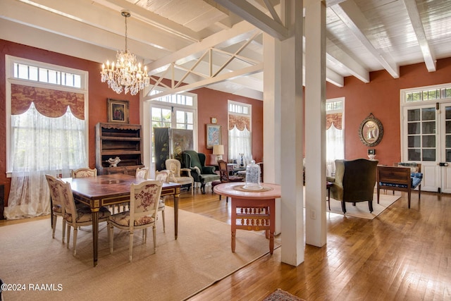 dining room with beamed ceiling, hardwood / wood-style floors, and a notable chandelier