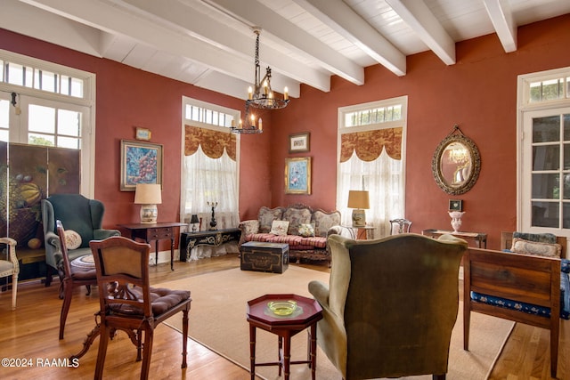 living room featuring beam ceiling, hardwood / wood-style flooring, and a chandelier