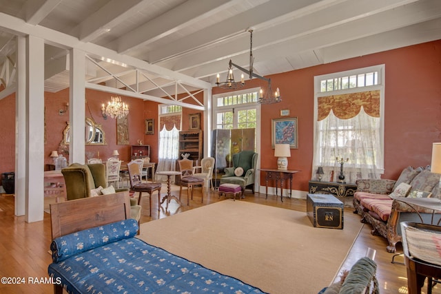 dining space featuring a chandelier, wood-type flooring, and beam ceiling