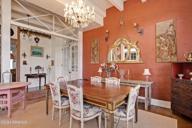 dining room with beam ceiling, an inviting chandelier, and hardwood / wood-style flooring