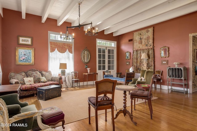 living room featuring beamed ceiling, hardwood / wood-style floors, and a notable chandelier