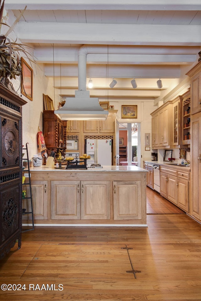 kitchen with light brown cabinetry, light hardwood / wood-style flooring, beam ceiling, and white appliances