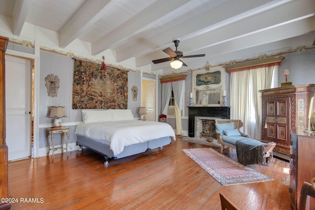 bedroom featuring hardwood / wood-style flooring, ceiling fan, and beamed ceiling