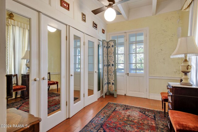 tiled entryway featuring french doors, ceiling fan, and beam ceiling