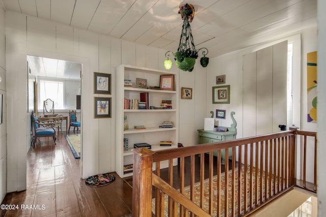 hallway with hardwood / wood-style floors and built in shelves