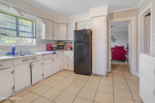 kitchen with light tile flooring, white cabinetry, and black fridge