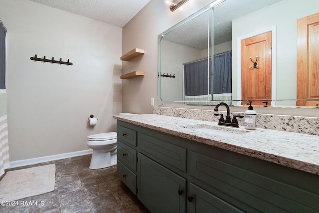 bathroom with toilet, oversized vanity, a textured ceiling, and tile flooring