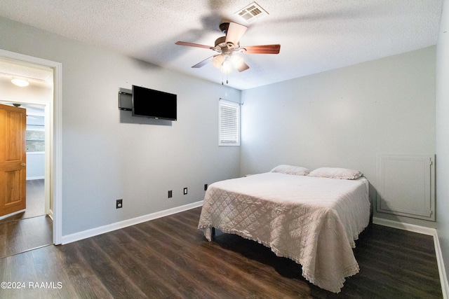 bedroom featuring ceiling fan, dark wood-type flooring, and a textured ceiling