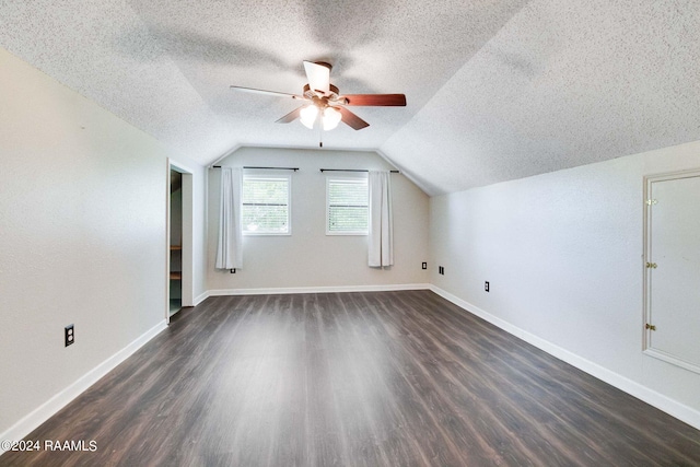 bonus room featuring a textured ceiling, vaulted ceiling, ceiling fan, and dark wood-type flooring