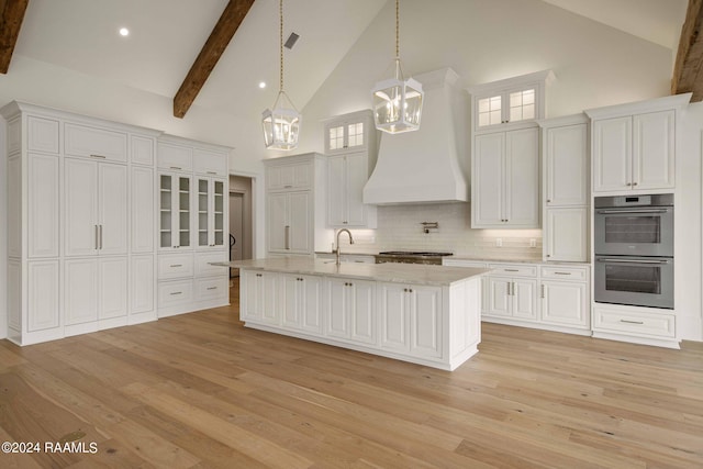 kitchen featuring tasteful backsplash, white cabinets, stainless steel appliances, and custom range hood