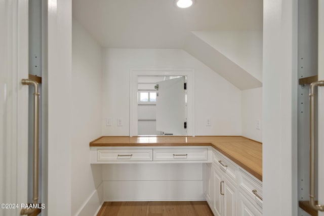 interior space with butcher block counters, white cabinetry, and light hardwood / wood-style flooring