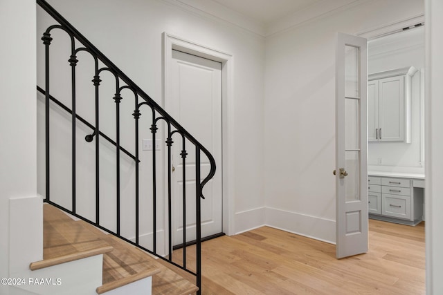 entrance foyer featuring light wood-type flooring and crown molding