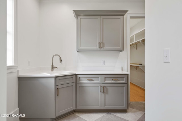 kitchen featuring light tile patterned floors, sink, and gray cabinets