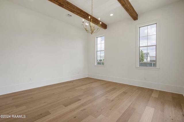 spare room with beam ceiling, light wood-type flooring, and a chandelier