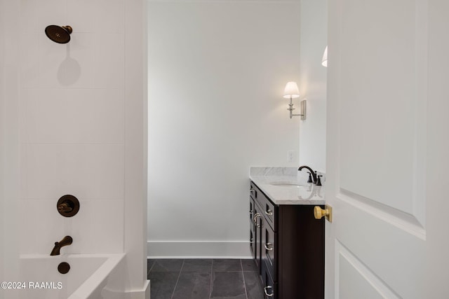 bathroom with tile patterned flooring, tiled shower / bath, and vanity