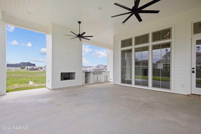 view of patio / terrace featuring area for grilling, ceiling fan, and an outdoor brick fireplace