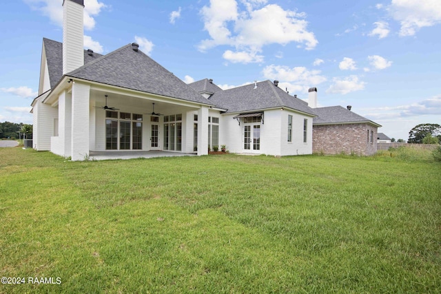 rear view of house featuring ceiling fan, a patio area, and a yard