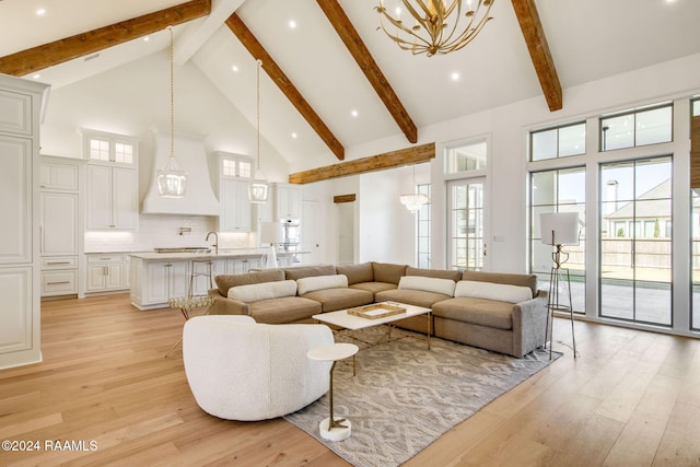 living room featuring beamed ceiling, sink, a chandelier, high vaulted ceiling, and light hardwood / wood-style flooring