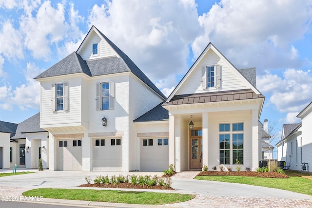 225 Gunter Grass Ct, Lafayette, LA 70508 - view of front facade with a standing seam roof, concrete driveway, metal roof, a shingled roof, and a garage