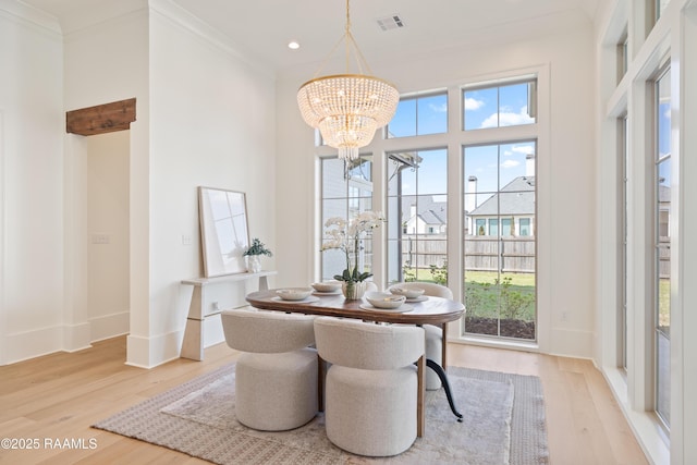 225 Gunter Grass Ct, Lafayette, LA 70508 - dining space featuring ornamental molding, visible vents, a chandelier, and light wood-type flooring