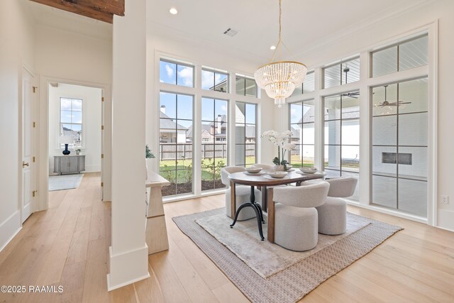225 Gunter Grass Ct, Lafayette, LA 70508 - dining area with light wood-style flooring, a healthy amount of sunlight, and a notable chandelier