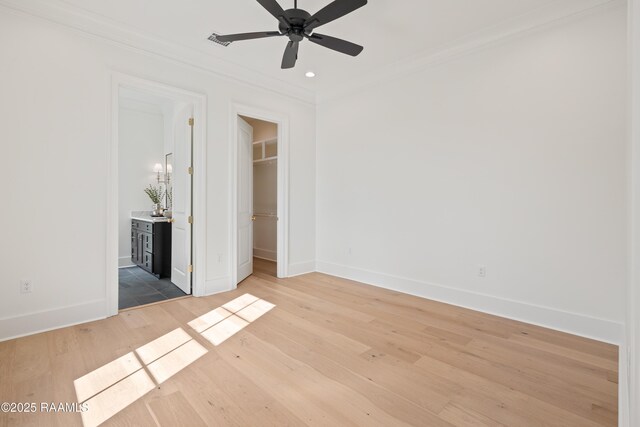 225 Gunter Grass Ct, Lafayette, LA 70508 - unfurnished bedroom featuring a closet, baseboards, ornamental molding, light wood-style floors, and a walk in closet